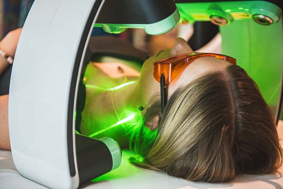 Body sculpting patient on the treatment table with green lasers